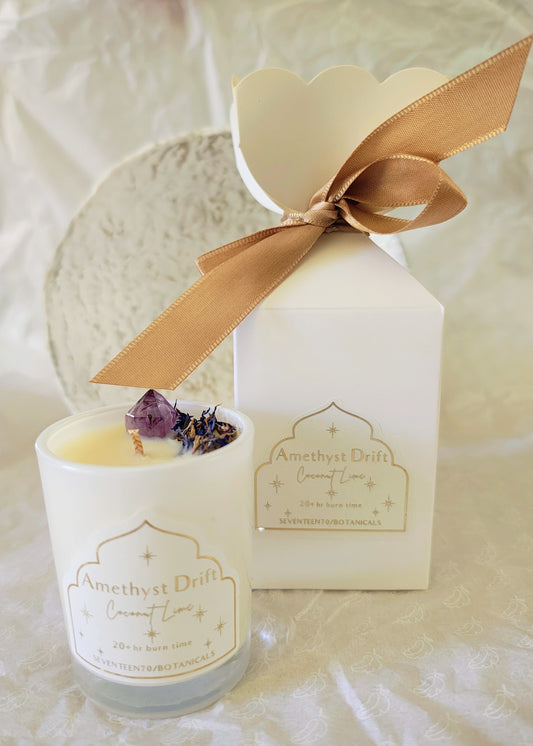 Candle with bon bon packaging featuring a gold bow on a light background