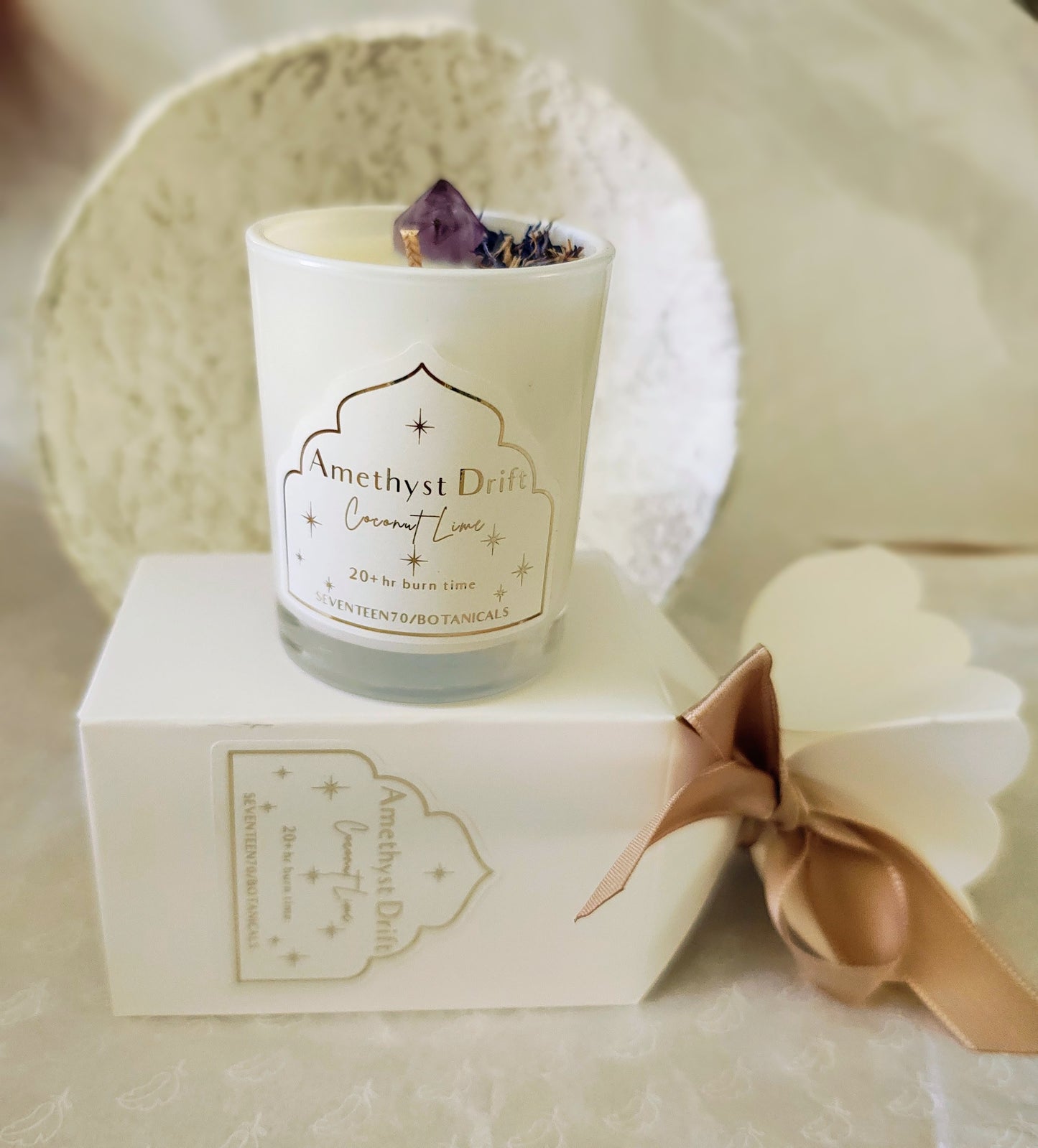 Candle with 'Amethyst Drift' branding on a white surface