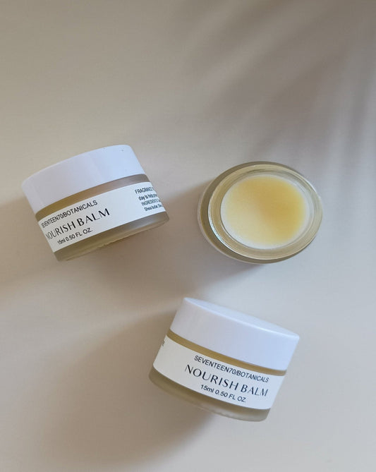 Three containers of Nourish Balm on a light background